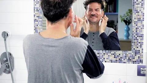 Man cleaning face and years in pajamas in bathroom slow motion Stock Footage 82178074