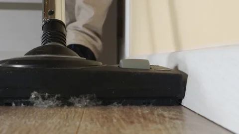 Man cleaning the floor from dust with vacuum cleaner. Close up video. Stock Footage 84404473
