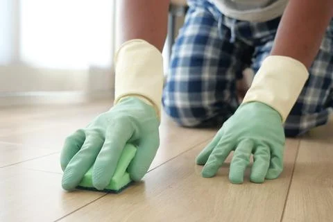 Man cleaning a floor using a sponge while wearing gloves Stock Photos