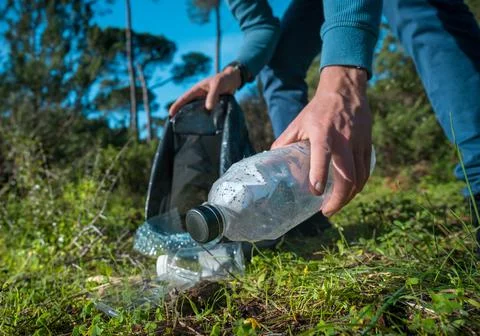 Man cleaning-up the forest of plastic garbage. Nature cleaning. Stock Photos