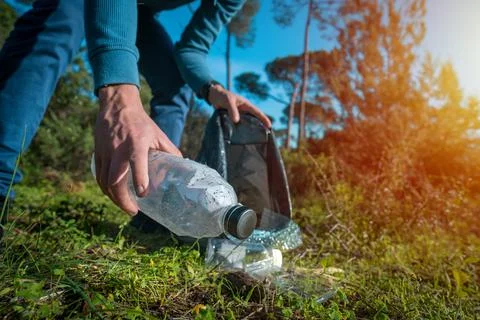 Man cleaning-up the forest of plastic garbage. Nature cleaning. Volunteer Stock Photos