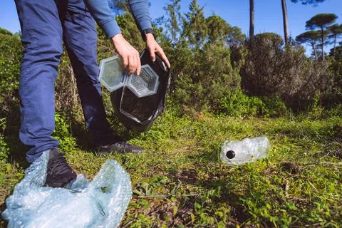 Man cleaning-up the forest of plastic garbage. Nature cleaning. Volunteer Stock Photos