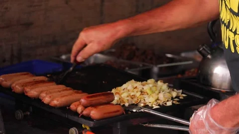 Man cleaning the frying pan and cooking street food - sausages, onion, eggs. Stock-Footage 201525697