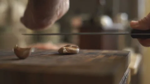Man is cleaning garlic with a knife video Stock Footage 85754861
