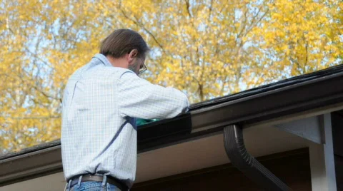 Man Cleaning Gutters in the Fall Stock Footage 733712
