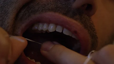 Man cleaning his teeth with thread Stock Footage 100009826
