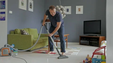 A man is cleaning at home, using vacuum cleaner Vídeos de archivo 51436474