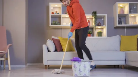 The man cleaning the house while having fun is dancing. Stock-Footage 222514286