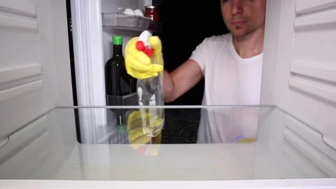 Man cleaning the inside of the fridge Video stock 135381305