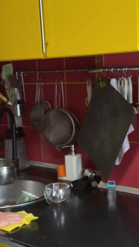 Man cleaning kitchen yellow kitchen with red tiles home in kitchen wearing Stockbeeldmateriaal 323510250