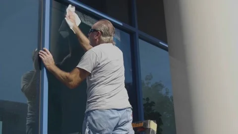 Man Cleaning Large Blue Window Stock Footage 209289925