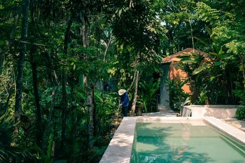Man cleaning next to the pool Stock Photos