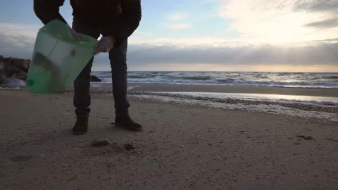 Man cleaning the plastic trash on the beach, volunteers teamwork. Stock Footage 168183554