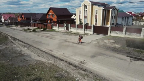 A man cleaning the road with a special device for laying new asphalt. aerial Stock Footage 153683956