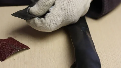 The man is cleaning the rubber patch with a file. For gluing puncture points  스톡 동영상 138760906