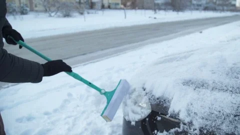The man is cleaning the snow from the car Stock Footage 83481577