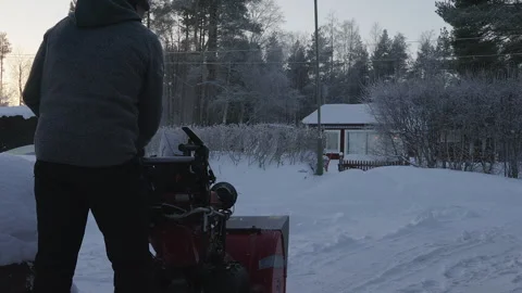 Man cleaning snow with snow blower machine at home, foggy frosty air on eve.. Stock Footage 264773848
