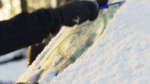 Man cleaning a snowy windshield Video stock 71432370