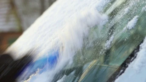 Man cleaning a snowy windshield Stock Footage 71434622
