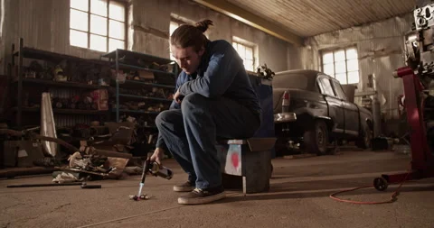 Man cleaning spark plug with blowtorch Stock Footage 221106982