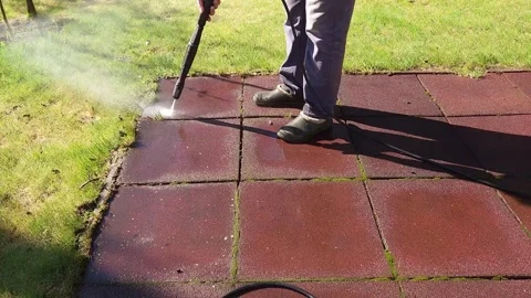 Man cleaning stone garden paths with high pressure power washer. Rubber-coated Video stock 275911704