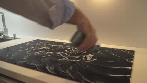 Man cleaning stove in kitchen Stock Footage 145420768
