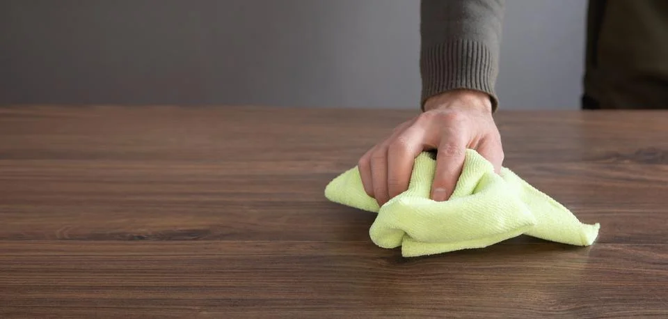 Man cleaning table using rag at home. Stock Photos
