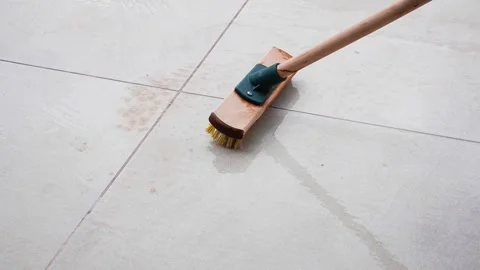 Man cleaning the tiles of the poolside with a floor scrubbing brush Stock Footage 279684900