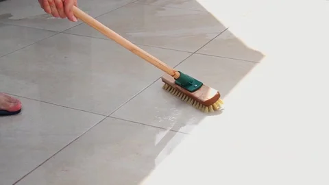 Man cleaning the tiles of the poolside with a floor scrubbing brush Stock Footage 279684904
