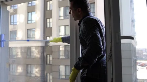 Man Cleaning Window At Home. A Worker Washes Windows In Office. Stock Footage 152592494