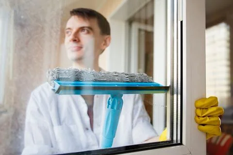 Man Cleaning Window With A Squeegee And Gloves Stock Photos