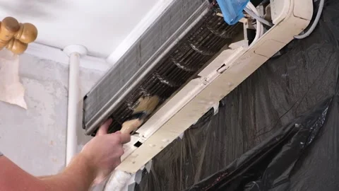Man cleans an air conditioner with a brush. Split system maintenance. Video stock 199312909