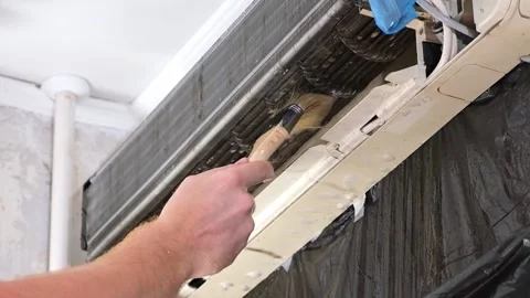 Man cleans an air conditioner with a brush. Split system maintenance. Video stock 201114971