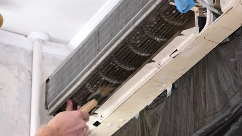 Man cleans an air conditioner with a brush. Split system maintenance. Stock Footage 201384507