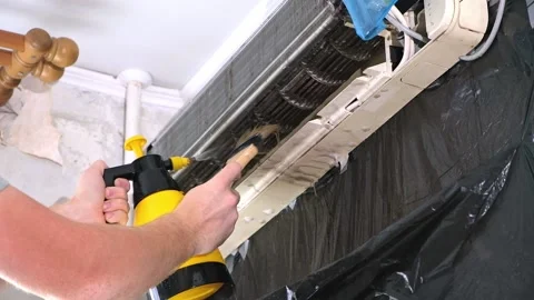 Man cleans an air conditioner with a brush. Split system maintenance. Video stock 201893726