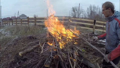 Man cleans and burns small trees on their own plot. Stock Footage 71817760