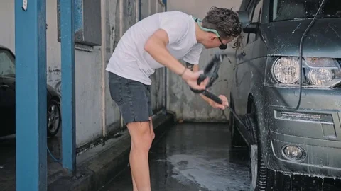 Man cleans big van or car at self service car wash Stock-Footage 79828184