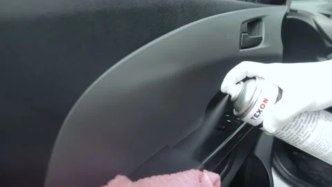 The man cleans the car from the dust using a damp cloth and spray. Stock Footage 130861522