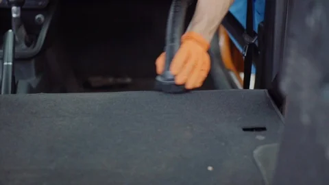 Man cleans car interior with vacuum cleaner Stock Footage 93482623