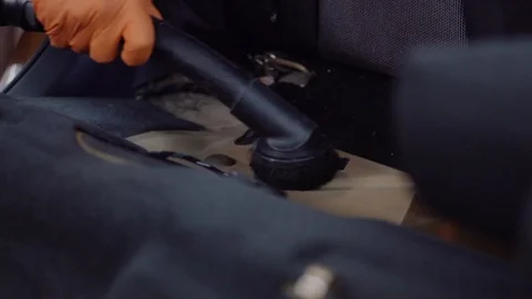 Man cleans car interior with vacuum cleaner Stock Footage 93484323
