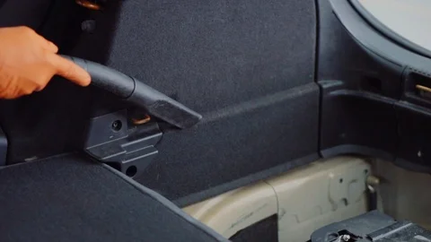 Man cleans car interior with vacuum cleaner Stock Footage 93485466