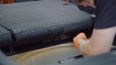 Man cleans car interior with vacuum cleaner Stock Footage 93485767