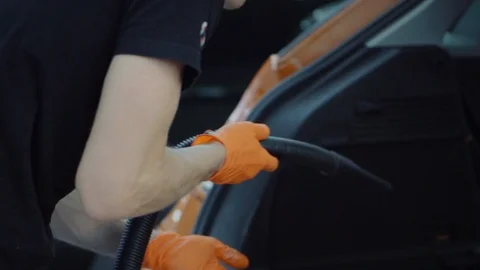 Man cleans car interior with vacuum cleaner Stock Footage 93486245