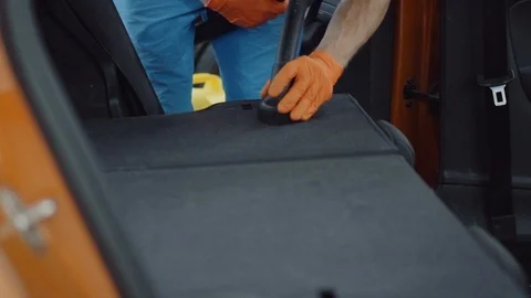 Man cleans car interior with vacuum cleaner Stock Footage 93487096