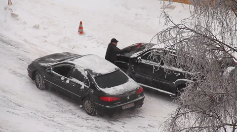 A man cleans a car from the snow Stock Footage 1002006