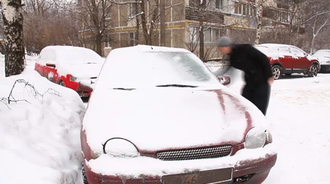 A man cleans a car from the snow time Laps Stock Footage 1002258