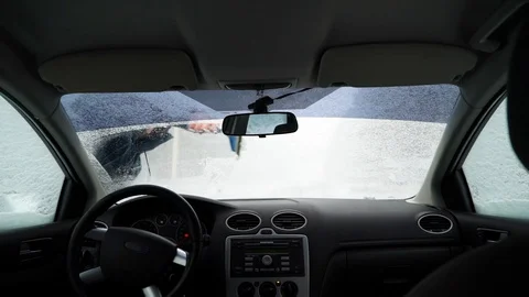Man cleans the car from the snow, the view from inside the car Video stock 88921610