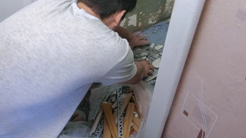 Man cleans up construction garbage after repair and renovation at home. 動画素材 119970562
