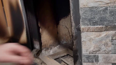 A man cleans the fireplace from the ash Stock Footage 100728621