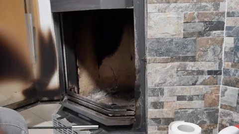 A man cleans the fireplace from the ash Stock Footage 100728875